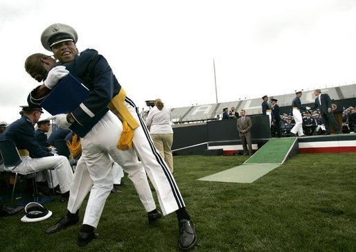 Graduating cadets celebrate after greeting President George W. Bush on stage, right, at the United States Air Force Academy Graduation Ceremony in Colorado Springs, Colorado, June 2, 2004. White House photo by Eric Draper.