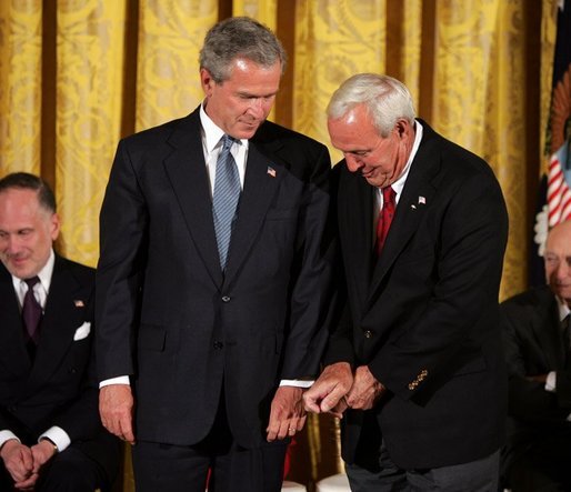 Recipient of the Presidential Medal of Freedom Arnold Palmer compares golf grips with President George W. Bush before receiving his award in the East Room of the White House on June 23, 2004. White House photo by Paul Morse