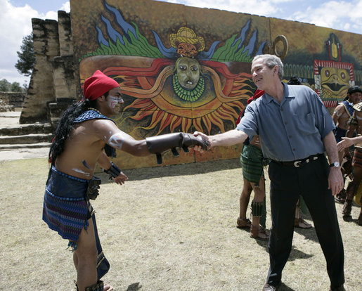 President George W. Bush reaches out to thank a performer Monday, March 12, 2007, after a demonstration of a Mayan Ritual competition at Iximche, Guatemala. White House photo by Eric Draper