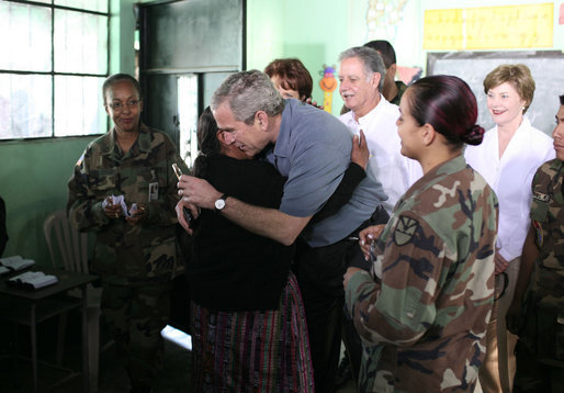 President George W. Bush gets a hug from a woman Monday, March 12, 2007, during a visit to a medical readiness and training exercise site at the Carlos Emilio Leonardo School in Santa Cruz Balanya, Guatemala. Also pictured is Guatemalan President Oscar Berger, center, and Mrs. Laura Bush. White House photo by Paul Morse