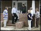 President George W. Bush is joined by Ernie Woodward of Long Beach, Miss., left, as he talks with Wendell Orr, center, a contractor, during the President’s tour Thursday, March 1, 2007, into a neighborhood where some homes damaged by Hurricane Katrina have been rebuilt with Gulf Coast grant money. White House photo by Eric Draper