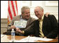 President George W. Bush is presented with a license plate with his name and the number 43 from Biloxi, Miss., Mayor A. J. Holloway, during a meeting Thursday, March 1, 2007 in Biloxi, on the recovery and reconstruction efforts underway in the region devastated by Hurricane Katrina. White House photo by Eric Draper