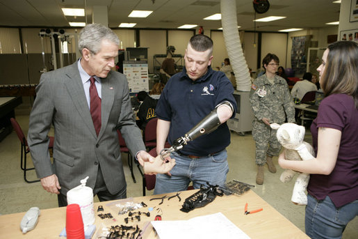 President George W. Bush talks with U.S. Army Sgt. Dennis Cline II of Memphis, Tenn., about therapy Friday, March 30, 2007, during a visit to Walter Reed Army Medical Center in Washington, D.C. Also pictured is Sgt. Cline’s wife Brooke Ann Cline. White House photo by Eric Draper