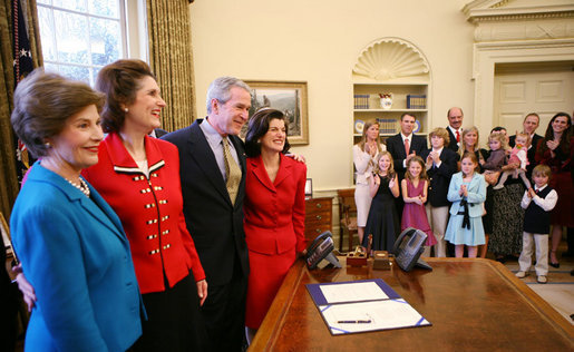 President George W. Bush and Mrs. Laura Bush embrace Lynda Bird Johnson Robb and Luci Baines Johnson, right, in the Oval Office, Friday, March 23, 2007, following the signing of H.R. 584 designating the U.S. Department of Education in Washington, D.C., as the Lyndon Baines Johnson Federal Building. White House photo by Eric Draper