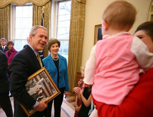 President George W. Bush and Mrs. Laura Bush greet the family members of former President Lyndon Baines Johnson in the Oval Office, Friday, March 23, 2007, for the signing of H.R. 584 designating the U.S. Department of Education in Washington, D.C., as the Lyndon Baines Johnson Federal Building. President Bush holds an old photo of President Johnson and Lady Bird Johnson to show members of the Johnson family. White House photo by Eric Draper