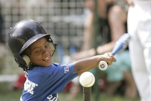 Shaquana Smith of the Jackie Robinson South Ward Little League Black Yankees of Newark, N.J., swings at the ball Sunday, June 26, 2005, during "Tee Ball on the South Lawn." White House photo by Paul Morse
