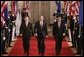 President George W. Bush leads European Union President Jean-Claude Juncker, left, and European Commission President Jose Manuel Barroso as they head to a joint press availability in the East Room Monday, June 20, 2005. White House photo by Paul Morse