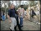 President George W. Bush walks with members of Jackulin "Jackie" Collins family, Tuesday, Oct. 11, 2005, while visiting a Habitat for Humanity building site in Covington, La., where a home for the Collins family is being built, along with others for victims of Hurricane Katrina. White House photo by Eric Draper