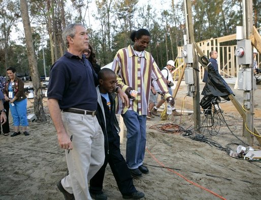 President George W. Bush walks with members of Jackulin "Jackie" Collins family, Tuesday, Oct. 11, 2005, while visiting a Habitat for Humanity building site in Covington, La., where a home for the Collins family is being built, along with others for victims of Hurricane Katrina. White House photo by Eric Draper