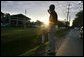 As the sun rises, President George W. Bush waves to the staff at Pine View Middle School Tuesday, Oct. 11, 2005, in Covington, La., where earlier he and Laura Bush joined a corps of Habitat for Humanity volunteers. White House photo by Eric Draper