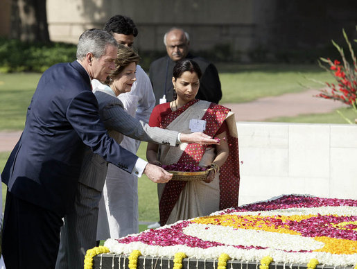 President George W. Bush and Laura Bush sprinkle flowers on the south side of the Mahatma Gandhi Memorial Thursday, March 2, 2006, during a wreath-laying ceremony in Rajghat, India. White House photo by Eric Draper