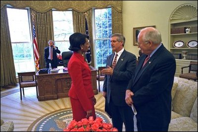 Chief of Staff Andy Card talks with National Security Advisor Dr. Condoleezza Rice and Vice President Dick Cheney as President Bush talks on the phone in the Oval Office March 18, 2003.