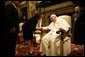 Mrs. Bush takes the hand of Pope John Paul II during the June 2004 visit to Rome by she and President Bush during which they presented the Pope with the Medal of Freedom White House photo by Eric Draper