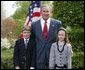 President George W. Bush congratulates siblings Alexander, 10, and Sara Reid, 8, of Central Elementary School of Belmont, Calif., on receiving the President’s Environmental Award in the East Garden April 22, 2004. White House photo by Susan Sterner.