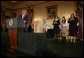 President George W. Bush acknowledges his guests, from left to right, Yamile Llanes Labrada, Melissa Gonzalez, and Marlenis Gonzalez during his remarks on Cuba policy, Wednesday, October 24, 2007, at the State Department in Washington, D.C. Labrada is the wife of Jorge Luis Garcia Paneque, a surgeon and journalist who was sentenced to 24 years in prison for speaking out against the regime. Melissa's father, Jorge Luis Gonzalez Tanquero is currently being held in a Cuban prison after being arrested for crimes against the state. White House photo by Eric Draper