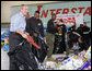 President George W. Bush helps U.S. Marines sort through a stack of toys Monday, Dec. 19, 2005 at the "Toys for Tots" collection center at the Naval District Washington Anacostia Annex in Washington, D.C. White House photo by Kimberlee Hewitt