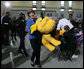 Mrs. Laura Bush helps carry a large stuffed animal to a toy distribution vehicle, Monday, Dec. 19, 2005, at the "Toys for Tots" collection center at the Naval District Washington Anacostia Annex in Washington, D.C., where she joined President George W. Bush in thanking the U.S. Marines for their charitable efforts. White House photo by Shealah Craighead