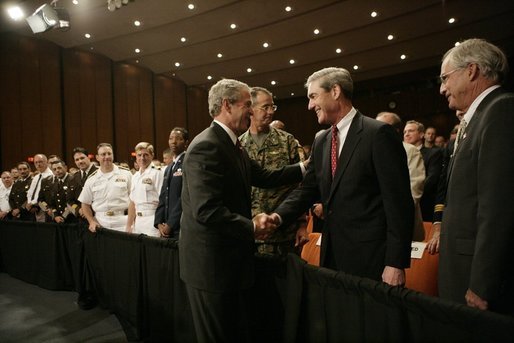 President George W. Bush shakes hands Monday, July 11, 2005, with Robert Mueller, Director of the Federal Bureau of Investigation as Porter Goss, right, Director of the Central Intelligence Agency, looks on. The President had just finished speaking on the war on terrorism at the FBI Academy in Quantico, Va. White House photo by Eric Draper