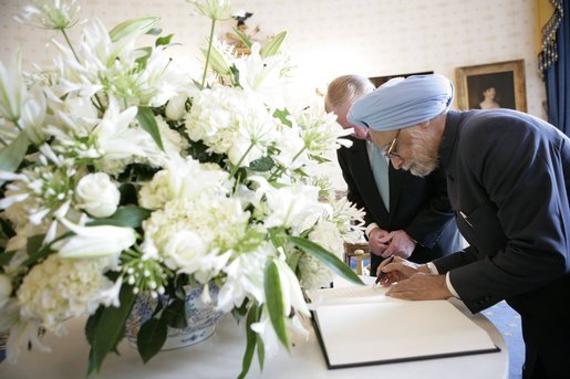 India's Prime Minister Dr. Manmohan Singh is accompanied by U.S. Department of State Chief of Protocal Ambassador Donald Ensenat, Monday, July 18, 2005, as Singh signs the guest book upon his arrival to the White House. White House photo by Eric Draper