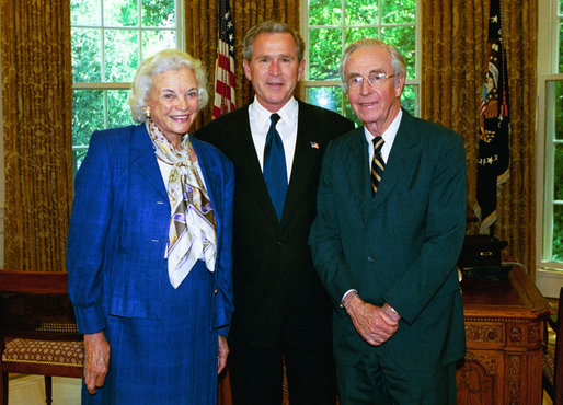 President George W. Bush stands with Supreme Court Justice Sandra Day O’Connor and her husband, John O’Connor, May 2004 in the Oval Office. Justice O’Connor submitted her resignation to the President Friday, July 1, 2005, after 24 years on the High Court to spend more time with her husband. File Photo. White House photo by Eric Draper