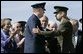 General Richard B. Myers, left, and General Peter Pace shake hands Friday, Sept. 30, 2005, during The Armed Forces Farewell Tribute in Honor of General Myers and the Armed Forces Hail in Honor of General Pace at Fort Myer's Summerall Field in Ft. Myer, Va., with Mary Jo Myers and President George W. Bush looking on. White House photo by Paul Morse