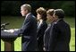 President George W. Bush discusses his decision to seek an injunction under the Taft-Hartley Act to stop the lockouts of America's western ports during a press conference on the South Lawn of the White House Tuesday, Oct. 8. Accompanying the President is Secretaries Elaine Chao, left, Ann Veneman, center, and Norm Mineta. White House photo by Tina Hager.