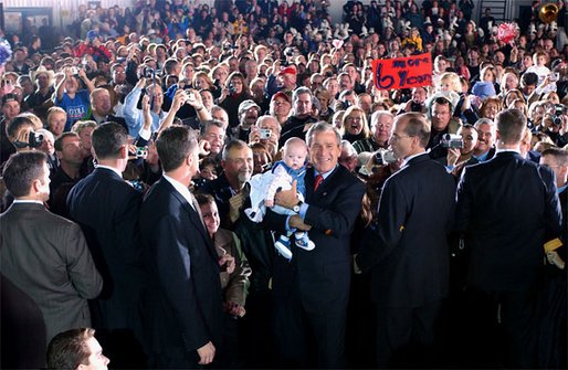 President George W. Bush poses with a baby while greeting the crowd during the Indiana Welcome at the South Bend Regional Airport in South Bend, Ind., Oct. 31. White House photo by Tina Hager.