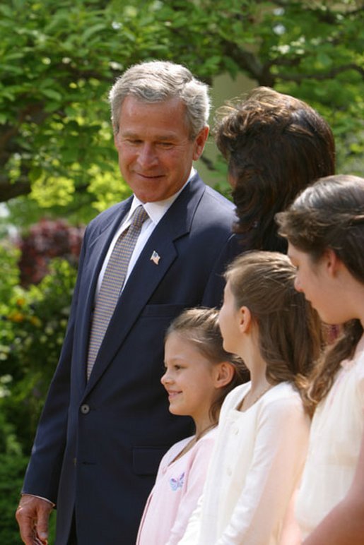 President George W. Bush looks toward Lacy Lyons, center, before signing the S. 151, PROTECT Act of 2003, in the Rose Garden Wednesday, April 30, 2003. Abducted by their father, Lacy, 10, and her sister Nyoka, 8, left, were found after an AMBER alert was activated throughout the state of Florida. White House photo by Paul Morse