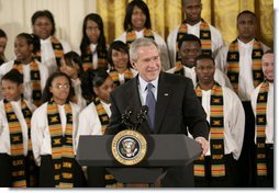 President George W. Bush, standing with members of the Jackson High School Black History Tour Group of Jackson, Mich., welcomes guests to the East Room of the White House, Monday, Feb. 12, 2007, during the celebration of African American History Month.  White House photo by Eric Draper