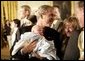 President George W. Bush holds one-month-old Trey Jones as he greets the audience Tuesday, May 24, 2005, after remarks on bioethics in the East Room of the White House. White House photo by Eric Draper