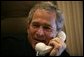 President George W. Bush smiles as he offers congratulations to Britain's Prime Minister Tony Blair during a phone call from Air Force One Friday, May 6 2005. White House photo by Eric Draper