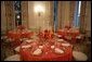 This is a view of the table settings in the State Dining Room, for the Thursday, Nov. 10, 2005 White House dinner, celebrating the National Endowment for the Arts and National Endowment for the Humanities 40th Anniversary. Chosen by Mrs. Laura Bush, the centerpieces are autumnal roses displayed in vermeil vases to compliment the Reagan China. White House photo by Paul Morse