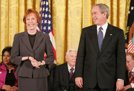 Carol Burnett jokes with President George W. Bush during the presentation of the Presidential Medal of Freedom to in the East Room Wednesday, Nov. 9, 2005. As a singer, dancer, comedienne, and actress, she has been one of America’s most cherished entertainers since her Broadway by in 1959. White House photo by Paul Morse
