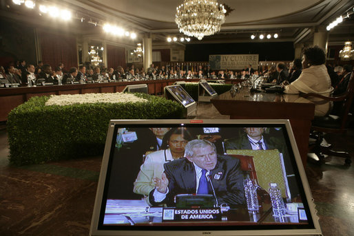 President George W. Bush and Secretary of State Condoleezza Rice are shown on a video monitor as the President speaks Friday, Nov. 4, 2005, during the opening session of the 2005 Summit of the Americas in Mar del Plata, Argentina. White House photo by Eric Draper