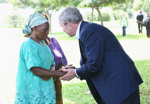 President George W. Bush meets with a family member Sunday, Feb. 17, 2008 at the memorial garden of the U.S. Embassy in Dar es Salaam in Tanzania, during a memorial remembrance for those who died in the 1998 U.S. Embassy bombing. White House photo by Eric Draper