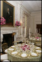 A portrait of President Abraham Lincoln is seen above the fireplace in the State Dining Room of the White House, as tables are set and decorated Tuesday, May 16, 2006, for the official dinner to honor Australian Prime Minister John Howard and his wife Janette Howard. White House photo by Shealah Craighead