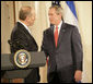 President George W. Bush and Prime Minister Ehud Olmert of Israel exchange handshakes Tuesday, May 23, 2006, at the end of a joint press availability in the East Room of the White House. White House photo by Eric Draper