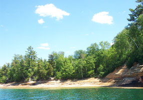 The Lake Superior shoreline near the mouth of the Mosquito River with beautiful blue skies and clear emerald water.