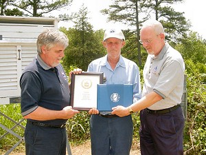 Mr. Russell Carter (second from left) of Evening Shade, AR holds a 30 Year Length-of-Service Award.