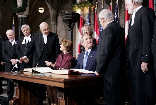 President George W. Bush and Laura Bush greet Parliament officials and sign guest books in the rotunda of Parliament Hill in Ottawa, Canada, Nov. 30, 2004.White House photo by Paul Morse