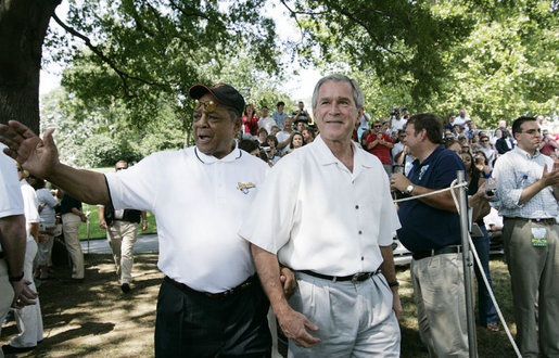 Baseball legend and hall of famer Willie Mays walks with President George W. Bush as he acknowledges a standing ovation from the crowd Sunday, July 30, 2006, upon their arrival for the Tee Ball on the South Lawn game between the Thurmont Little League Civitan Club of Frederick Challengers of Thurmont, Md., and the Shady Spring Little League Challenger Braves of Shady Spring, W. Va. Mays was the honorary Tee Ball Commissioner for the game. White House photo by Paul Morse