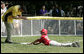 A member of the Thurmont Little League Civitan Club of Frederick Challengers of Thurmont, Md., is applauded by third base coach Dan Wilson as he slides into third base Sunday, July 30, 2006, at the White House Tee Ball on the South Lawn game against the Shady Spring Little League Challenger Braves of Shady Spring W. Va. White House photo by Paul Morse