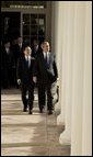 After the Arrival Ceremony, President George W. Bush and Premier Wen Jiabao of China walk along the Rose Garden Colonnade on their way to the Oval Office Tuesday, Dec. 9, 2003. "We're going to have extensive discussions today on a lot of issues," said the President during an Oval Office meeting with the media. "We've just had a very friendly and candid discussion. There's no question in my mind that when China and the United States works closely together we can accomplish a lot of very important objectives." White House photo by Paul Morse