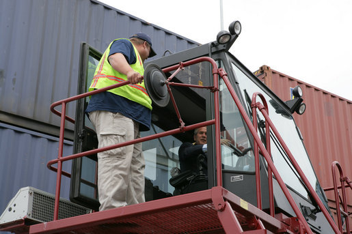 President George W. Bush sits inside the cab of a stacker as its operator, Frederick Bishop, looks on Tuesday, March 18, 2008, during a tour of Coastal Maritime Stevedoring, LLC at the Blount Island Marine Terminal in Jacksonville, Fla. White House photo by Chris Greenberg