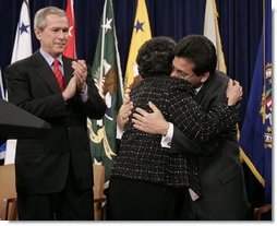 As President Bush leads the applause, Attorney General Alberto Gonzales embraces his mother, Maria, after he was ceremoniously sworn into office Monday, Feb. 14, 2005, at the Justice Department.  White House photo by Paul Morse