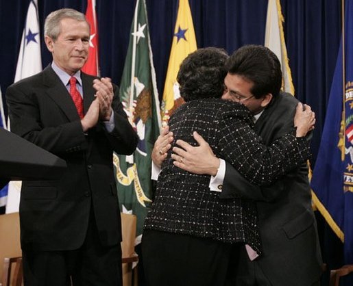 As President Bush leads the applause, Attorney General Alberto Gonzales embraces his mother, Maria, after he was ceremoniously sworn into office Monday, Feb. 14, 2005, at the Justice Department. White House photo by Paul Morse.