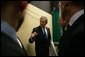 President George W. Bush speaks with his staff before a Feb. 22, 2005 joint news conference with NATO Secretary General Jaap de Hoop Scheffer at NATO headquarters in Brussels. White House photo by Eric Draper