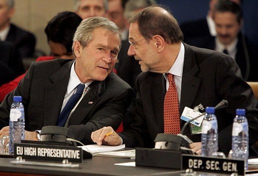 President George W. Bush speaks with European Union High Representative Javier Solana during a plenary session of the North Atlantic Council at NATO Headquarters in Brussels Tuesday, Feb. 22, 2005. White House photo by Eric Draper