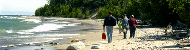 Visitors to Pictured Rocks National Lakeshore enjoy the beautiful beaches of Lake Superior as the waves roll gently in.