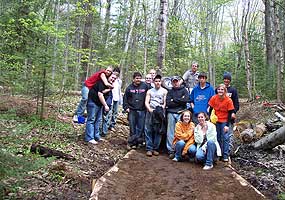 High school students proudly pose with the work they accomplished along this trail.